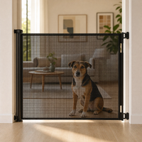 Retractable safety gate extended across a doorway with a dog sitting calmly behind the mesh View 8